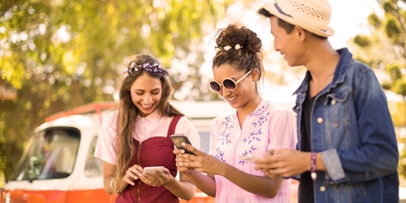 Junge Menschen mit Smartphone im Urlaub